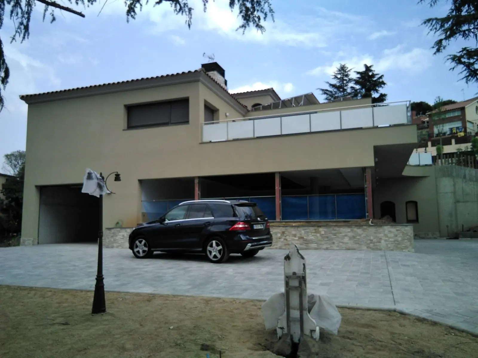Fachada terminada. Vivienda unifamiliar reformada con carpinterías de arco y urbanización.