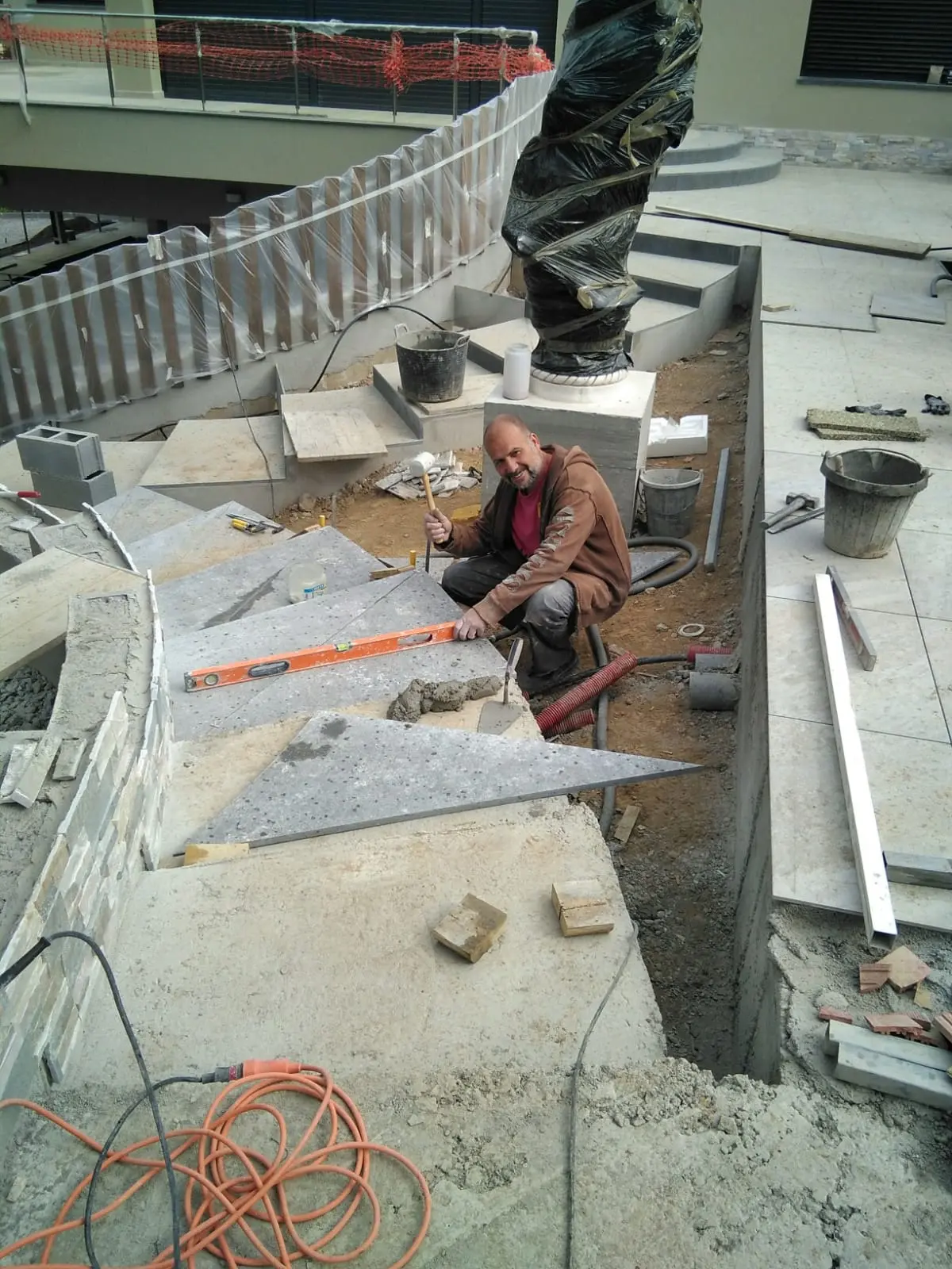 Acceso rodado con adoquín de hormigón. Muros curvos de piedra natural.