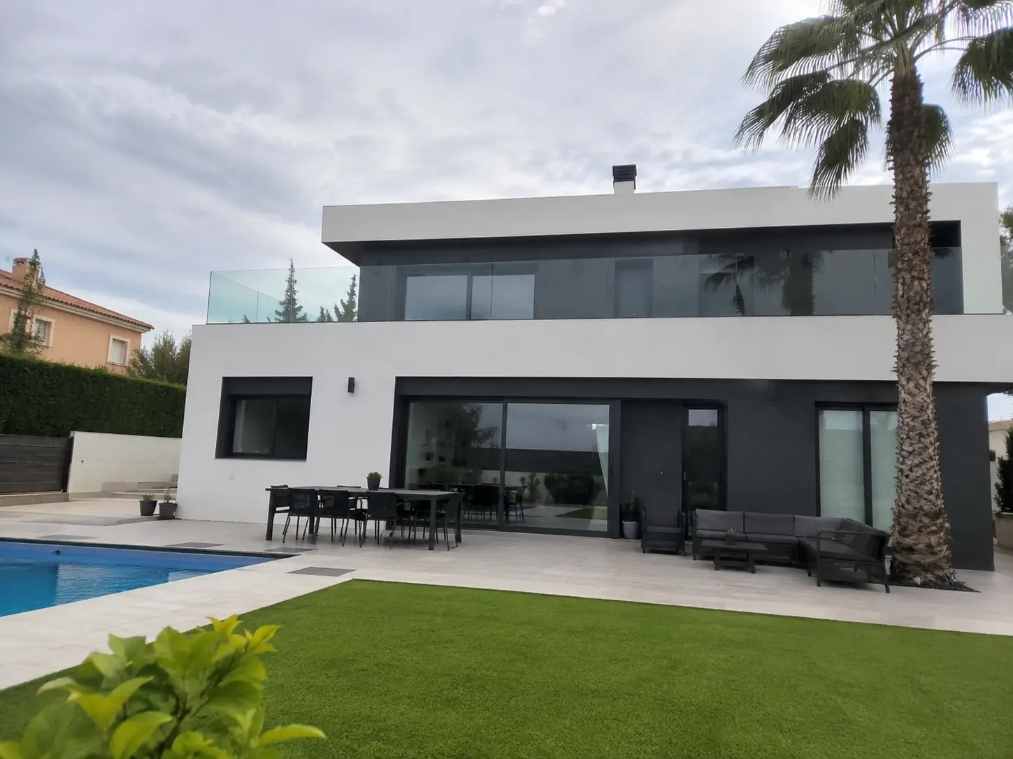 Inicio Vivienda de obra nueva moderna de dos plantas con fachada blanca, grandes ventanales, piscina y jardín