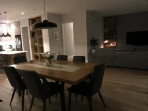Comedor reformado con mesa de madera y sillas tapizadas, integrado con el salón